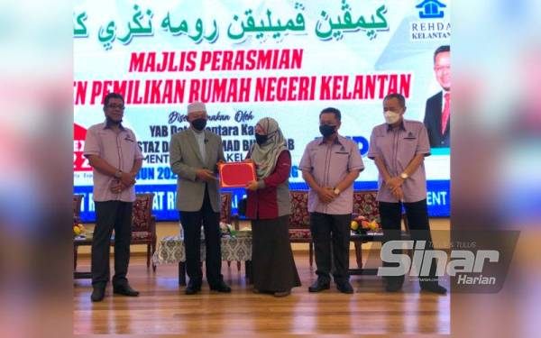 Pengarah Konsumer Bank Islam Negeri Kelantan, Nurol’ain Abg Latip (tengah) menerima Sijil Penyertaan Kempen Pemilikan Rumah Negeri Kelantan yang disampaikan Menteri Besar Kelantan di Mydin Tunjong, Kota Bharu pada Rabu.
