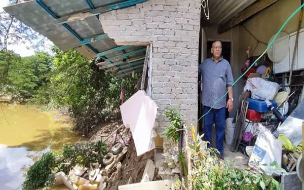 Azhar menunjukkan sebahagian dapur dan stor rumahnya yang runtuh dan jatuh ke Sungai Padang Terap di Kampung Seri Pasir, Kepala Batas dalam kejadian pagi Isnin lalu.
