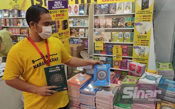 Mohd Hasrul menunjukkan antara nota M#QuranTime yang dijual di reruai Karangkraf di PBAKL, di WTCKL pada Khamis.