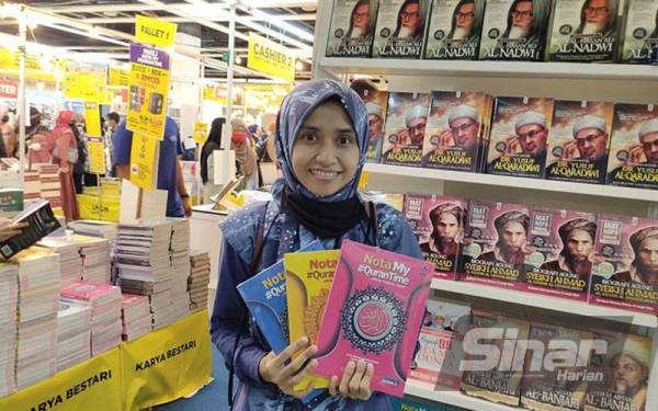 Atiqah menunjukkan nota My#QuranTime yang dibeli di reruai Karangkraf di PBAKL, di WTCKL, di sini, pada Khamis.