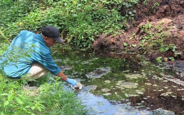 Penguat kuasa JAS mengambil contoh air yang tercemar di Sungai Bahai, Kluang.