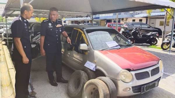 Wan Mohd Zahari (kanan) menunjukkan kereta curi dan beberapa barang kes lain yang dirampas susulan penahanan dua suspek anggota Geng Padil' Rabu lalu.