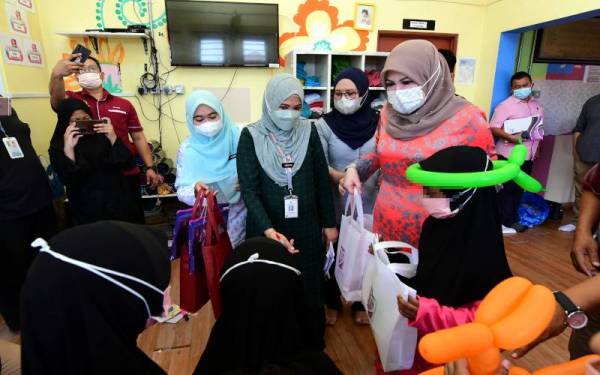 Menteri Pembangunan Wanita, Keluarga dan Masyarakat Datuk Seri Rina Mohd Harun menyantuni kanak-kanak ketika melawat Rumah Kanak-Kanak Mini Ulu Tiram, pada Sabtu. - Foto Bernama