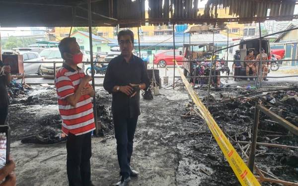 Johari (kanan) melawat peniaga yang terjejas akibat kebakaran di Pasar Keramat, Kampung Datuk Keramat.