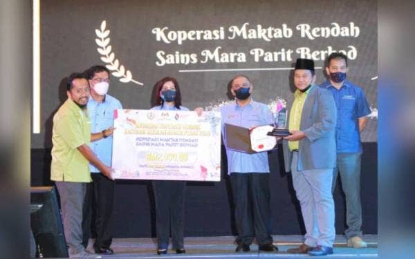 Saarani (tiga dari kanan) menyampaikan anugerah koperasi terbaik bagi kategori sekolah kepada Koperasi Maktab Rendah Sains Mara Parit Berhad sempena Hari Koperasi Negara peringkat negeri Perak 2022 di sini pada Sabtu.