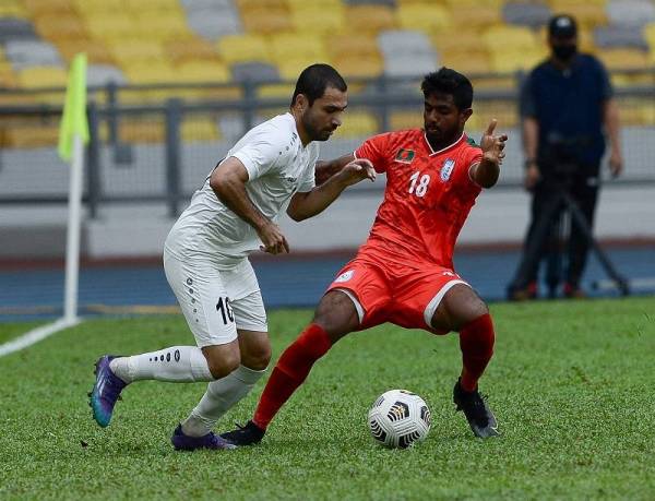 Pemain Bangladesh, Md Rimon Hossain menghalang pemain Turkmenistan, Tagayev Elman pada aksi Kumpulan E Kelayakan Piala Asia 2023 di Stadium Nasional Bukit Jalil petang tadi. Foto Bernama