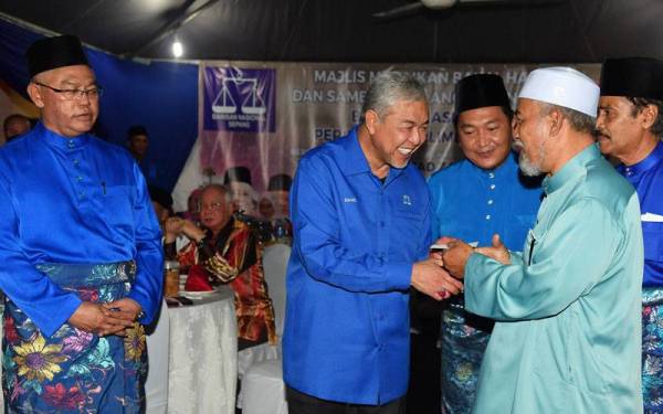 Ahmad Zahid (dua dari kiri) menyampaikan sumbangan kepada bakal jemaah haji pada Majlis Meraikan Bakal Haji dan Sambutan Ulang Tahun Ke-48 Barisan Nasional Peringkat Parlimen Sepang di Bangunan UMNO Sepang malam Ahad. Foto: Bernama