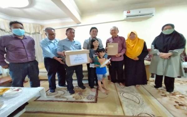 Zamani (empat kiri) dan Zainol (tiga kiri) menyempurnakan penyerahan sumbangan Kotak Prihatin dan Bayaran Faedah Pengurusan Jenazah serta pencen penakat kepada Aminuddin (tiga kanan), pada Isnin.