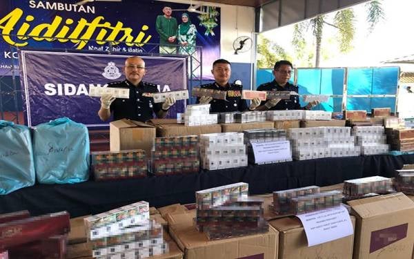 Mohd Nor Yhazid (tengah) menunjukkan rokok yang dirampas oleh PDRM pada Ahad.