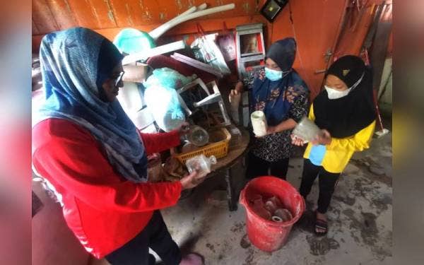 Lateeffah (kiri) membantu Aini memilih pinggang mangkuk yang masih boleh digunakan.