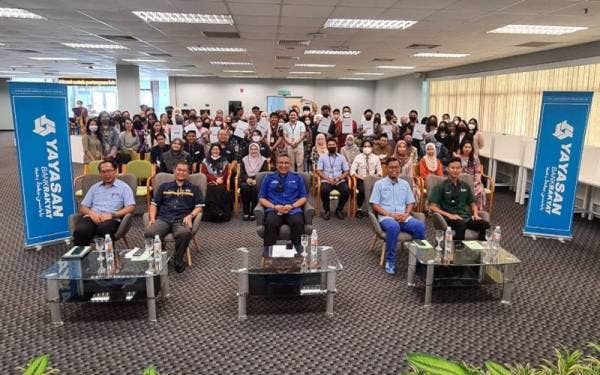 Megat Zulkarnain (duduk tengah) bergambar bersama pelajar yang menerima bantuan YBR selepas majlis penyerahan bantuan awal pengajian Yayasan Bank Rakyat pada Selasa.