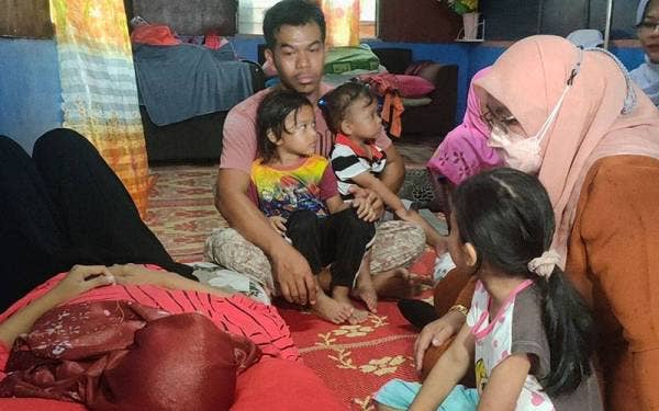 Tuminah (kanan) ketika mengunjungi Nurhabibah yang terlantar sakit di Kampung Pantai Puteri, Tanjung Kling, di sini, pada Rabu.