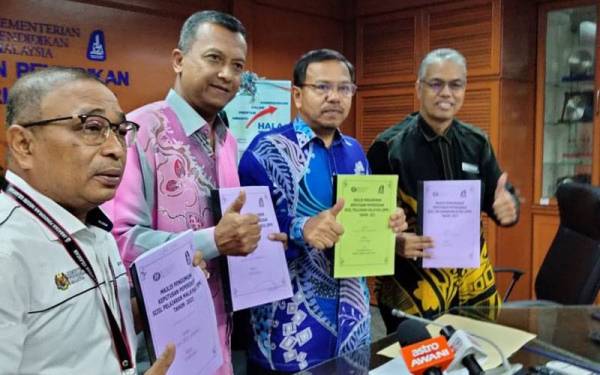 Mohamad (dua dari kanan) menunjukkan keputusan SPM yang diumumkan pada Khamis.