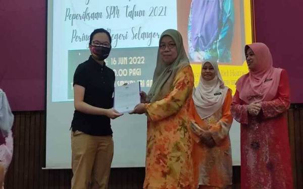 Rohayati (dua dari kiri) memberikan sijil keputusan peperiksaan SPM kepada pelajar cemerlang SPM di SMK (P) Sri Aman, di sini pada Khamis.