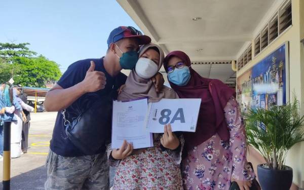 Farah Qistina (tengah) bersama ibu bapanya selepas mengambil keputusan SPM di SMK (P) Sri Aman, Petaling Jaya pada Khamis.