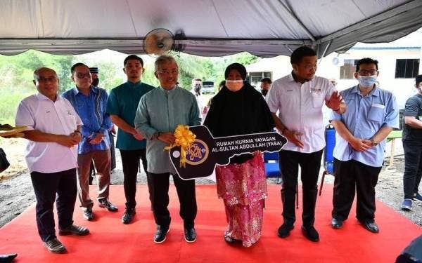 Yang di-Pertuan Agong Al-Sultan Abdullah Ri'ayatuddin Al-Mustafa Billah Shah (empat dari kiri) menyerahkan replika kunci kepada salah seorang pemilik rumah.