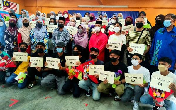 Nur Syafiqah (belakang, empat kiri) bersama rakan-rakannya yang memperolehi keputusan cemerlang di SMK Bukit Rambai, Melaka pada Rabu.