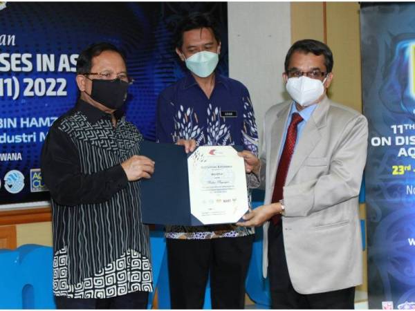 Ahmad (à gauche) présente le certificat de coopération aux organisateurs impliqués.