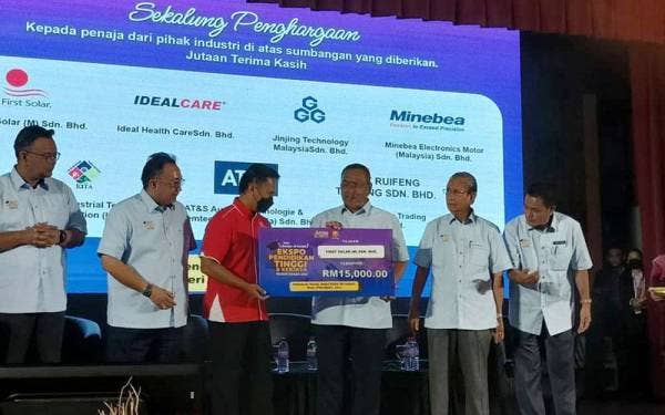 Muhammad Sanusi (tiga dari kanan) menyerahkan replika cek kepada penaja daripada First Solar Sdn Bhd di Majlis Perasmian Ekspo Pendidikan dan Kerjaya di Politeknik Sultan Abdul Halim Mu'adzam Shah di Jitra pada Jumaat.