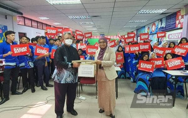 Nurhayati (kanan) menyampaikan cenderamata kepada Mohd Ali.