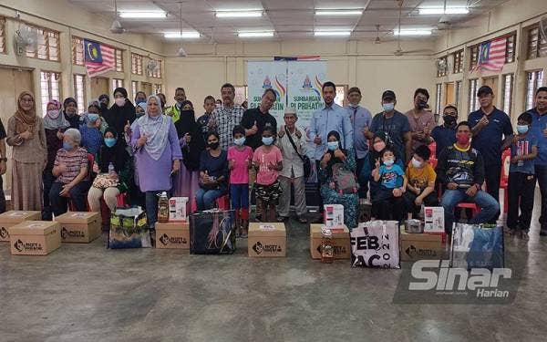 Mohamad Azhan (tengah) bersama para penerima sumbangan Program PJ Prihatin di PPR Lembah Subang 1, di sini pada Sabtu.