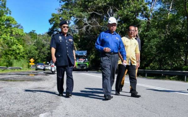 Mustapa (dua, kiri) bersama Mohd Suhaili (dua, kanan) meninjau sebahagian laluan Lebuhraya Timur-Barat di sempadan Gerik, Perak dan Jeli pada Ahad.- Foto Bernama