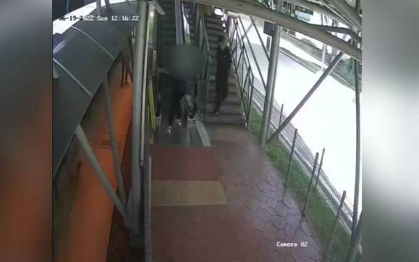 Tangkap layar rakaman CCTV memaparkan seorang remaja menekan butang kecemasan di eskalator berdekatan stesen LRT Sri Rampai.