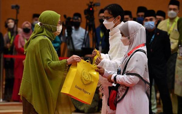 Raja Permaisuri Agong Tunku Hajah Azizah Aminah Maimunah Iskandariah (kiri) berkenan menyampaikan cenderahati dan menyantuni para jemaah pada Majlis Mengucapkan Selamat Jalan kepada Jemaah Haji Malaysia ke Tanah Suci Mekah Musim Haji 1443H/2022M di Kompleks Haji Sepang (Movenpick) hari ini.