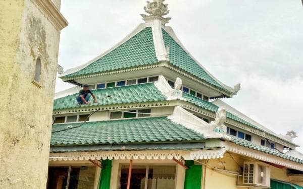 Atap genting masjid yang mengalami kerosakan akibat terkena serpihan batu menara.