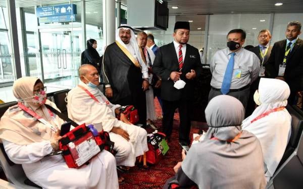 Timbalan Menteri di Jabatan Perdana Menteri (Hal Ehwal Agama) Datuk Ahmad Marzuk Shaary bersama Duta Besar Arab Saudi ke Malaysia Datuk Dr Mahmoud Hussien Saeed Qatta menyantuni jemaah haji semasa melawat kemudahan ‘Makkah Route’ yang disediakan Kedutaan Besar Arab Saudi di Lapangan Terbang Antarabangsa Kuala Lumpur (KLIA), pada Rabu. - Foto Bernama

