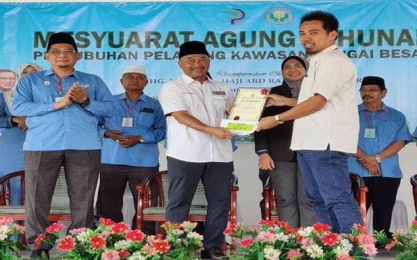 Abd Rahman (dua dari kanan) menyampaikan sijil penghargaan kepada salah seorang ahli PPK Sungai Besar pada Majlis Perasmian Mesyuarat Agung Tahunan PPK Sungai Besar Kali ke-41 di Dewan Terbuka Dataran PPK Sungai Besar pada Khamis.