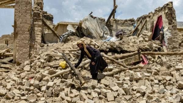 Penduduk di perkampungan Ghurza, Afghanistan melalui runtuhan rumah yang musnah dalam gempa bumi berukuran 6.1 pada skala Richter yang melanda daerah Bermal, wilayah Paktika. Foto AFP