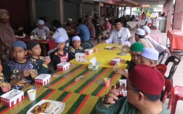 Mohd Kholib (tengah) bersama pelajar Tahfiz Baitul Musthofa pada Majlis Tahlil dan Doa Selamat di Medan Selera Mergong, Alor Setar pada Khamis.