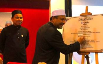 Mohd Nassuruddin (kanan) menandatangani plak Perasmian Klinik, Hospital dan Farmasi Patuh Syariah Pertama di Malaysia di Kota Bharu pada Isnin.