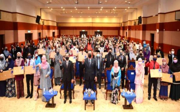 Naib Canselor UUM, Profesor Dr Haim Hilman Abdullah (tengah) bersama pelajar menerima komputer riba sempena Majlis Penyerahan Komputer Riba FWD Takaful Berhad kepada pelajar UUM di Dewan Sri Angsana EDC-UUM, pada Isnin.