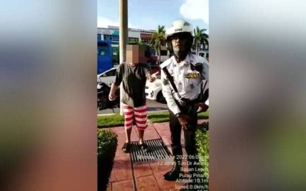 Tangkap layar video tular yang memaparkan pergelutan antara suspek dengan anggota polis trafik.