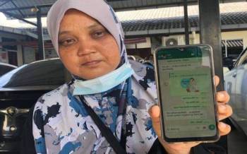 Siti Jainah menunjukkan pesanan WhatsApp terakhir yang diterima dari adiknya pada pagi hari kejadian.