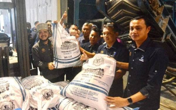 Nik Muhammad Zawawi (kiri) mengadakan lawatan di Pusat Pengeluaran Benih Padi PPK Lahar Bubu di Kepala Batas.