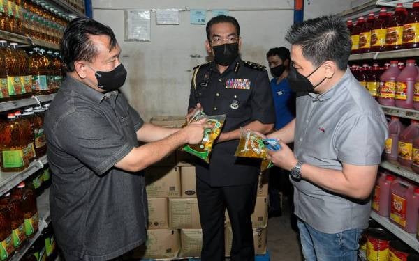 Nanta (kiri) dan Pengarah Penguatkuasa KPDNHEP, Azman Adam (tengah) melihat stok minyak masak peket semasa membuat pemeriksaan harga siling ayam dan telur ayam di Pasaraya Checkers, Seksyen 15, Shah Alam pada Jumaat. - Foto Bernama
