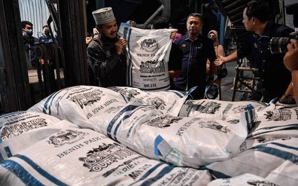 Timbalan Menteri Pertanian dan Industri Makanan II Datuk Dr Nik Muhammad Zawawi Salleh (kiri) melihat bungkusan benih padi ketika melakukan lawatan di Pusat Pengeluaran Benih Padi Pertubuhan Peladang Kawasan Lahar Bubu hari ini.