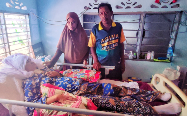 Farihah Zakaria (kiri) ditemani bapanya, Zakaria Yaakub menguruskan ibunya, Rozita Aroff yang terlantar di Kampung Kubang Kuar, mukim Ayer Puteh, Pendang.