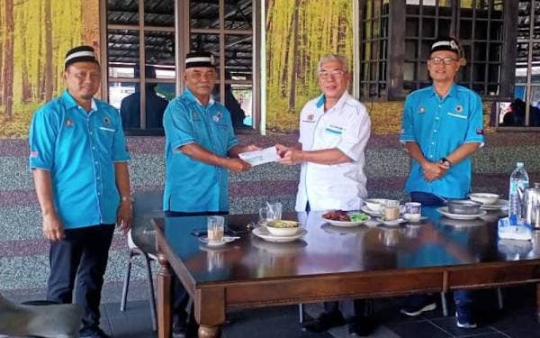 Hassan (dua dari kanan) memberikan sumbangan kepada pesara ATM selepas bertemu anggota PVATTBM Cawangan Pasir Gudang di Taman Desa Perwira, Pasir Gudang, pada Sabtu.