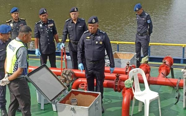 Kamarul Zaman (kiri) melihat tempat penyimpanan diesel kapal tangki digunakan sindiket di Sungai Bauk, Tanjung Belungkor Kota Tinggi pada Ahad.