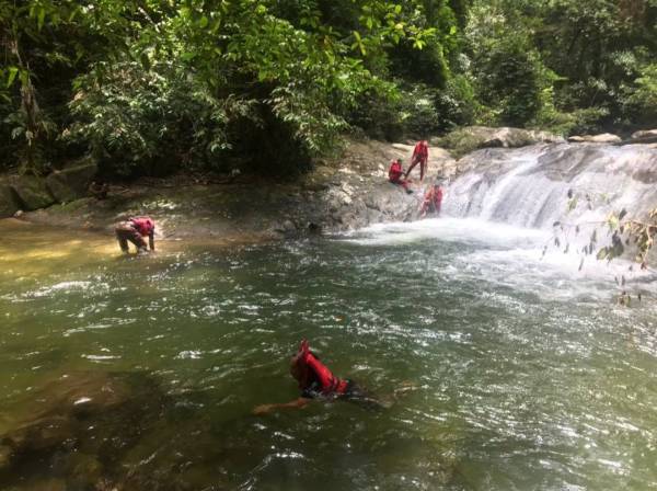 Pasukan bomba menjalankan operasi mengesan mangsa selepas menerima laporan kejadian lemas di air terjun Batu Pecah, Trong pada Ahad.