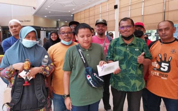 Khairul Anwar (tengah) ditemani ibunya, Maznah (kiri) dan bapanya, Zakaria (dua, kiri) menerima hadiah disampaikan Ketua Bahagian Perkhidmatan Perpustakaan Dan Maklumat PPAT, Muhaisham Ibrahim (dua, kanan).