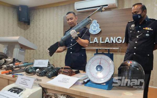 Ahmad Ridhwan menunjukkan senjata api tiruan yang dirampas susulan tumpasnya Geng Bajing dalam serbuan di Bukit Changgang, Kuala Langat pada 29 Jun lalu.