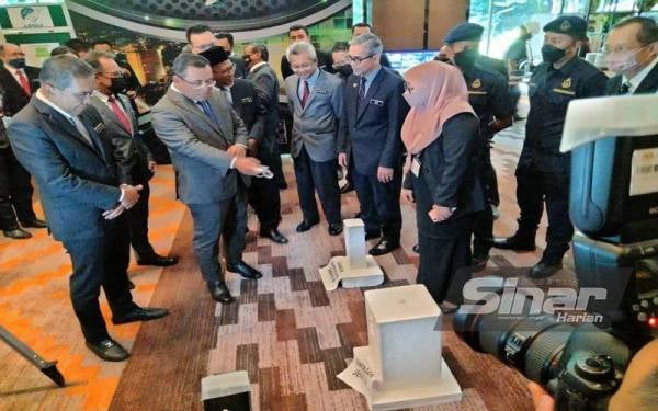 Takiyuddin (kiri) bersama Amirudin (dua kiri) melihat contoh batu penanda yang dipamerkan di ruang pameran disediakan.