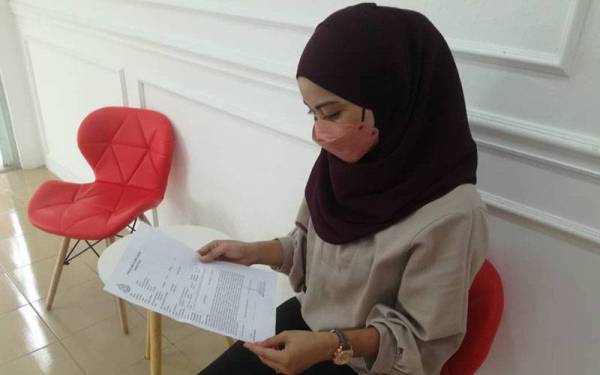 Nuraqilah Nadhirah melihat laporan polis yang dibuatnya pada 29 Jun lepas.