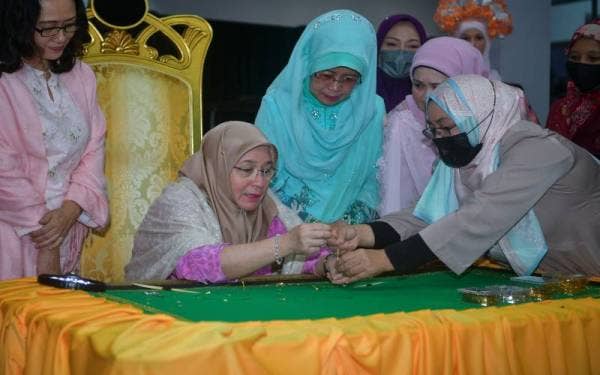 Raja Permaisuri Agong Tunku Hajah Azizah Aminah Maimunah Iskandariah berkenan mencuba bakat menyulam keringkam ketika melawat Akademi Teknologi Warisan dan Gastronomi di Pusat Kecemerlangan Teknikal Sarawak (Centexs), pada Isnin. - Foto Bernama