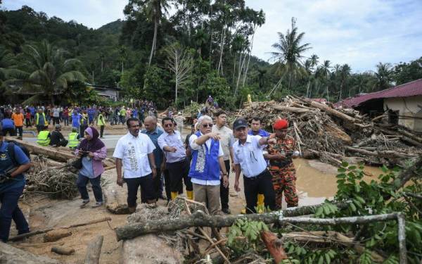 Setiausaha Politik Perdana Menteri, Datuk Mohammad Anuar Mohd Yunus meninjau keadaan Sungai Latar Celak, Kupang yang dipenuhi timbunan kayu balak selepas dibawa arus deras. - Foto Bernama